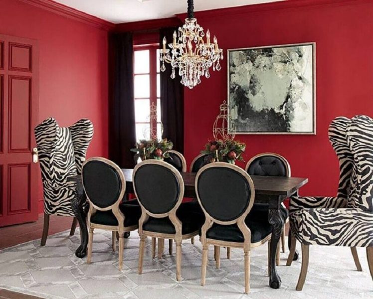  Decoração para sala de jantar com paredes vermelhas e mesa petra com poltronas com tecido de zebra.
